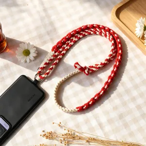 Red and white braided phone lanyard strap with adjustable length, stylish woven accessory.