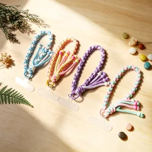 Hand-woven colorful cotton phone lanyards with transparent connector pads on wood surface