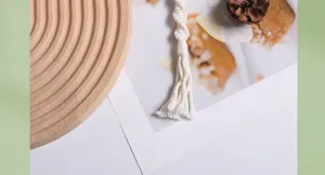 Macro shot of a handmade cream macrame keychain featuring textured cotton fringe