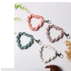 Close-up of handmade woven heart-shaped phone wristlets in multiple pastel colors