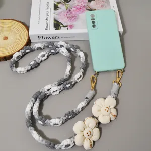 Böhmische geflochtene Handykette mit süßen Gänseblümchen Anhängern und grüner Hülle.