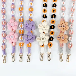 Böhmisch geflochtene Handykette mit süßen Gänseblümchen-Anhängern und Lächeln-Stickerei.