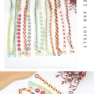 Close-up detail of colorful hand-woven flower phone straps and crossbody bag straps
