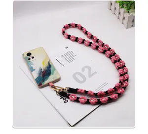 Macro view of Bohemian woven daisy flower phone lanyard resting on a white magazine