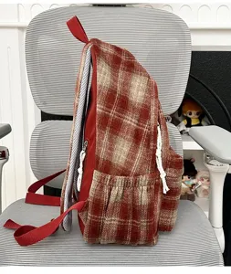 Side detail view of a retro plaid backpack showcasing side pocket and strap construction.