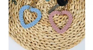 Detaillierte Makroansicht von hellblauen und rosa Makramee-Herz-Schlüsselanhängern