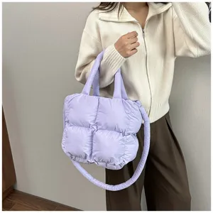 Detail of purple puffer tote bag with quilted texture and padded strap