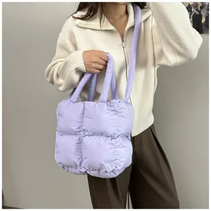 Light purple puffer quilted tote bag shown on a model for a casual winter look