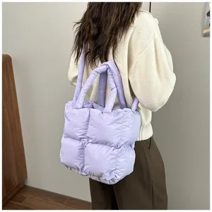 Back view of a stylish purple quilted puffer tote bag carried over the shoulder with ease