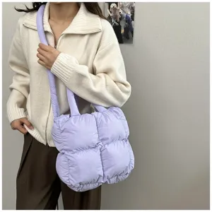 Woman wearing a large purple quilted puffer tote bag for casual autumn winter fashion