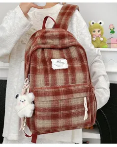 Cozy fuzzy plaid backpack detail, featuring soft fleece fabric, spacious compartment, and cute bear charm.