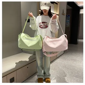 Modelo asiática con bolsas de viaje y fitness grandes en color verde claro y rosa