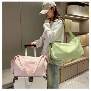 Modelo llevando grandes bolsas de deporte y viaje verdes y rosas en un viaje