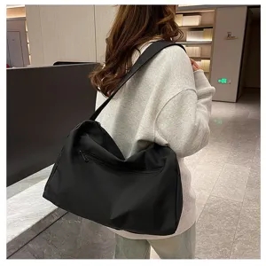 Foto de estilo de vida de una mujer con un bolso de fitness negro grande