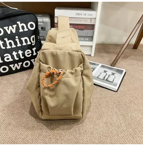 Side view of a khaki nylon dumpling bag featuring an orange decorative drawstring