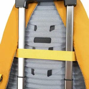 Detail view of a yellow outdoor backpack secured to a silver suitcase trolley handle via back strap.