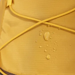 Macro shot of yellow waterproof fabric detail on outdoor backpack with clear water beads
