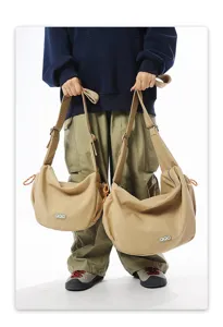 Two sizes of khaki crossbody dumpling bags shown with person as size reference
