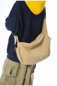 Professional view of a khaki large-capacity nylon dumpling messenger bag on a model