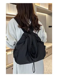 Black nylon drawstring backpack for women, casual lightweight school bookbag, daily commuter bag.