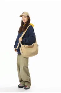 Trendy large khaki crossbody dumpling bag worn by a female model for casual commute