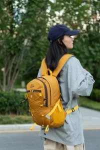 Woman wearing a mustard yellow large capacity outdoor hiking backpack in a natural park.