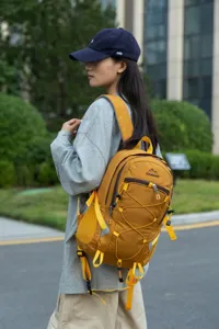 Large yellow outdoor hiking backpack shown on female model in an urban park setting