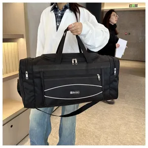 Vue détaillée du sac de voyage noir montrant une poignée solide et grande capacité.