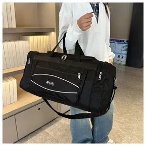 Vue détaillée du grand sac de voyage noir avec poignées solides et sangle d'épaule pratique.