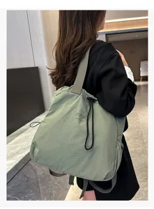 Detail view of the casual nylon backpack in light green, featuring modern drawstring design.