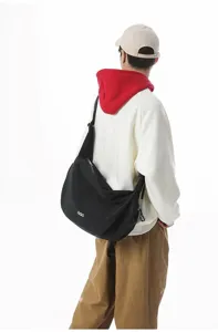 Close-up back view of a black large-capacity dumpling crossbody bag worn by a model
