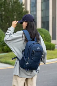 Professional outdoor photo of a woman wearing a navy blue large capacity hiking backpack