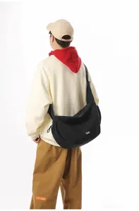 Back view of a black large capacity nylon crossbody dumpling bag worn by model