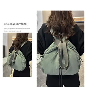 Detail shot of the casual nylon drawstring backpack worn on back, showing large capacity.