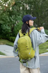 Lightweight green hiking backpack for outdoor sports shown worn by a female model outdoors.
