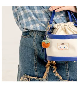 Detailansicht eines niedlichen handgestrickten Kakis-Anhängers für Taschen mit Metallring