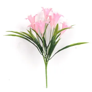 Gros plan détaillé d'un bouquet de fleurs de trompette roses artificielles avec feuilles.