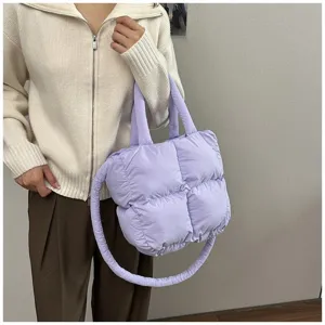 Detailed shot of a light purple quilted puffer tote bag featuring soft padding and circular strap