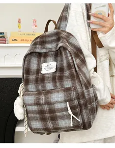Detailed view of retro plaid backpack with cozy design, adjustable straps and front pocket.