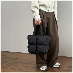Stylish black quilted puffer tote bag with large capacity for trendy winter outfits
