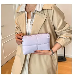 Detail einer weichen, gesteppten lilafarbenen Kosmetiktasche, gehalten von einem Model