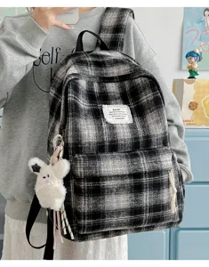 Retro plaid backpack for women, vintage wool fabric school bag with cute plush pendant accessory.