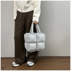 Detailed shot of a light grey quilted puffy tote bag made of warm padded fabric for winter