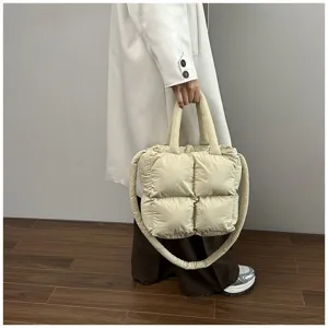 Beige quilted padded tote bag with large capacity shown as a shoulder bag on model