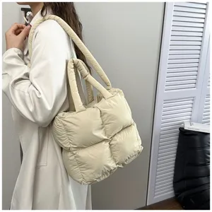 Detailed view of cream puffer tote bag worn over the shoulder