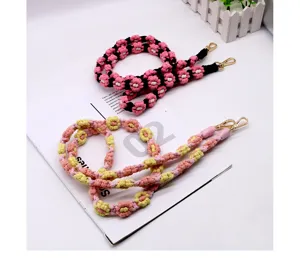 Close-up of handmade woven daisy flower mobile phone lanyards with metal lobster clasps.