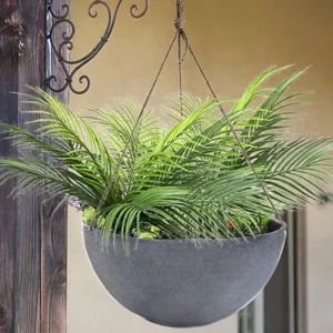 Gros plan d'un palmier artificiel suspendu dans un pot gris à texture de pierre