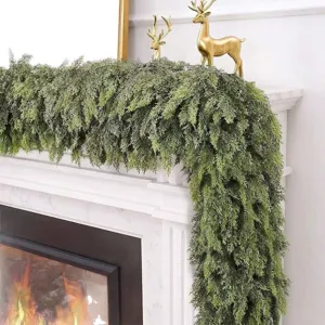 Realistic artificial cedar greenery garland draped over a white fireplace mantel