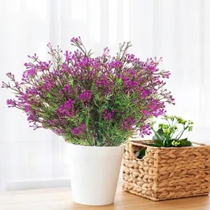 Lush artificial purple plastic flowers with green leaves in a minimalist white pot