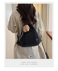 Stylish black triangle backpack for women shown from the back with plush charm